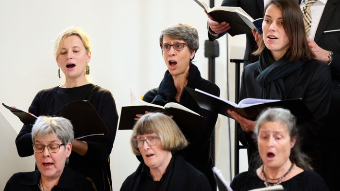 Ein gemischter Chor singt aus Notenbüchern