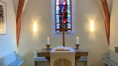 Kleine Kapelle mit Buntglasfenster, Altar und Kirchenbänken