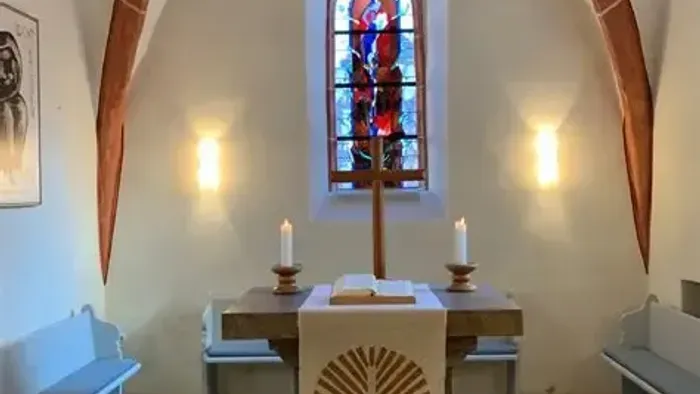 Kleine Kapelle mit Buntglasfenster, Altar und Kirchenbänken