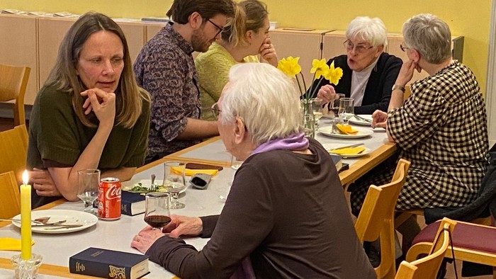 En gruppe mennesker sidder ved et bord og diskuterer.