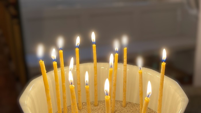 Hvid skål med tændte lys i kirken.