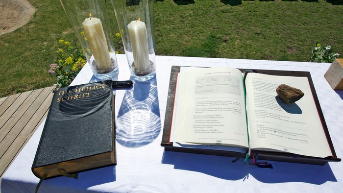 Ein Tisch mit Kerzen, Büchern und einer Schale im Freien