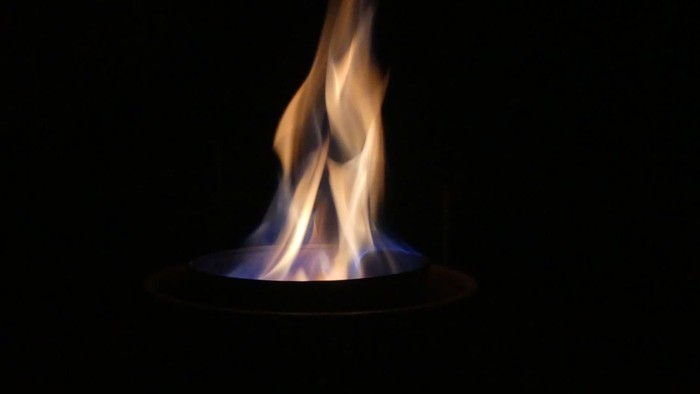 Ein einzelner Flammenstoß auf schwarzem Hintergrund.