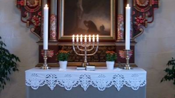 Altaret i kirken med lysestage og billede