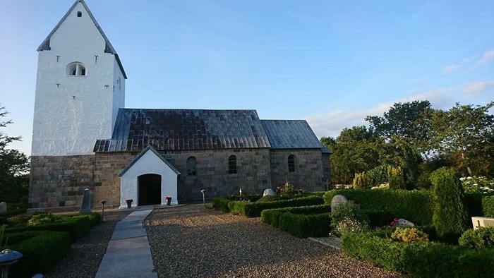 En smuk kirke med tårn og omgivelser