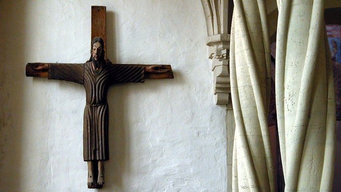 Ein hölzernes Kruzifix an einer weißen Wand