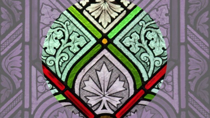 Das Bild zeigt ein farbenfrohes Buntglasfenster mit einem Wappen.