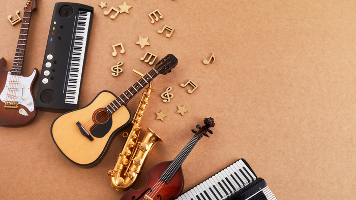 Bunte Musikinstrumente und goldene Noten verstreut auf einem strukturierten Hintergrund.