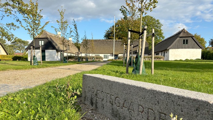 Maleriagtigt landskab med en idyllisk gård prydet med skiltet