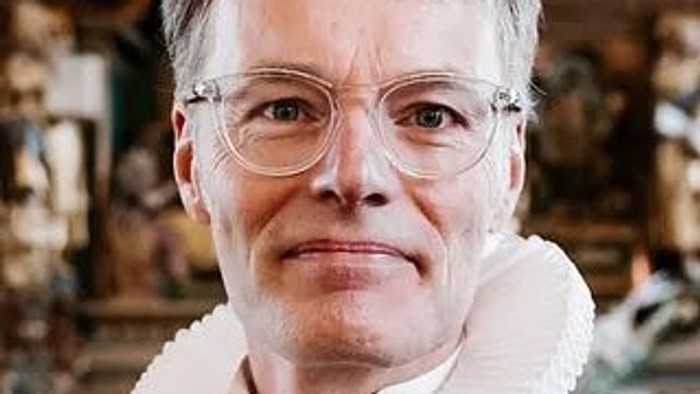 Kvinde med briller og hvid krave.