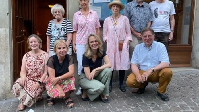 Eine Gruppe von Menschen posiert vor einem Gebäude