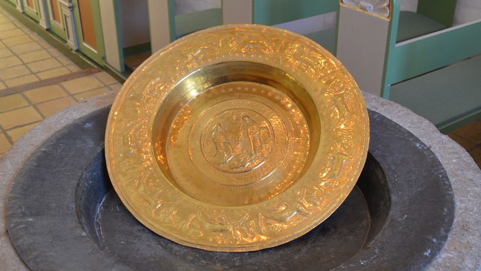 Gul gylden skål på font i kirke
