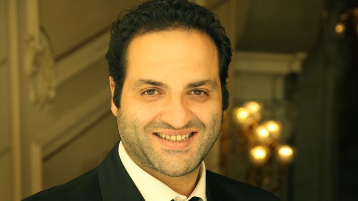 Ein Mann in Anzug hält eine Geige