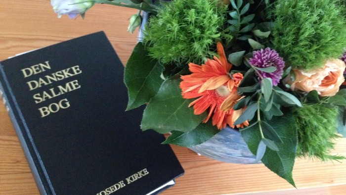 En bog og en blomsterstang på bordet