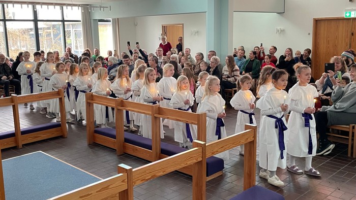 En gruppe børn i hvide kjoler går luciaoptog i Mosede Kirke.