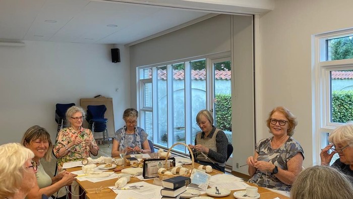 En gruppe pensionister sidder ved et bord og spiser.