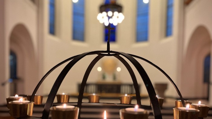 En kandleholder med flere lyse lygter i en kirke
