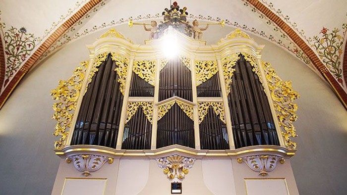 Prachtvolle Kirchenorgel mit goldenen Verzierungen und aufwendiger Deckenmalerei