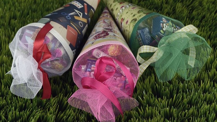 Drei Geschenke in Papier mit Schleifen auf grünem Teppich