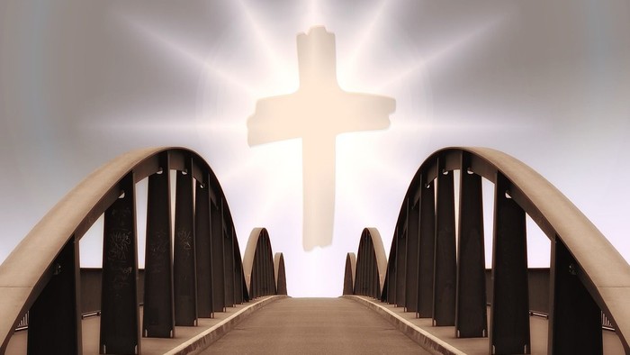 Ein weißes Kreuz in einem Raum mit schwarzen Bögen und einem Mittelgang