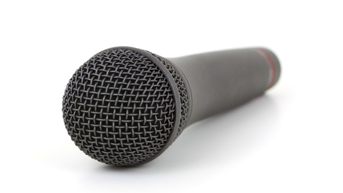 Et sort mikrofon med mesh foran på hvid baggrund