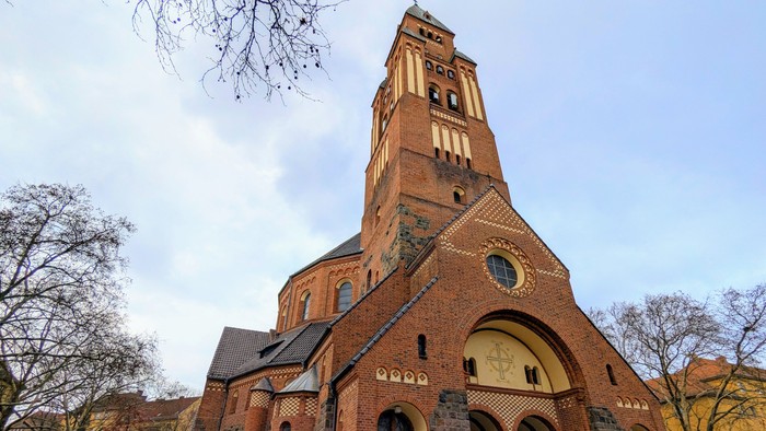 Große Ziegelkirche mit hohem Turm und Rundbogenfenster