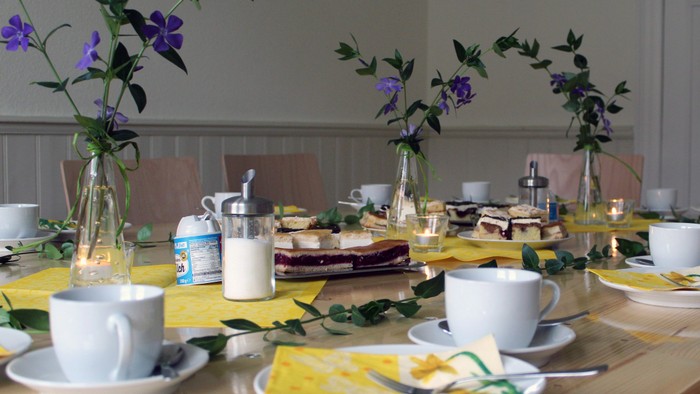 Tisch gedeckt mit Tassen, Untertassen und Sandwiches