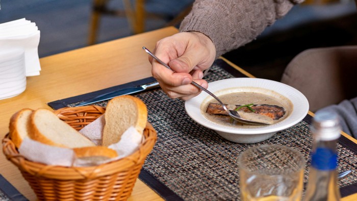 Person isst Suppe und Brot in einem Restaurant