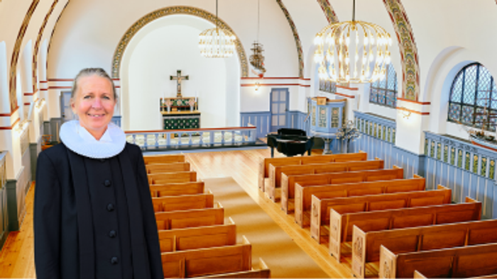En præst står i en kirke med træbænke.