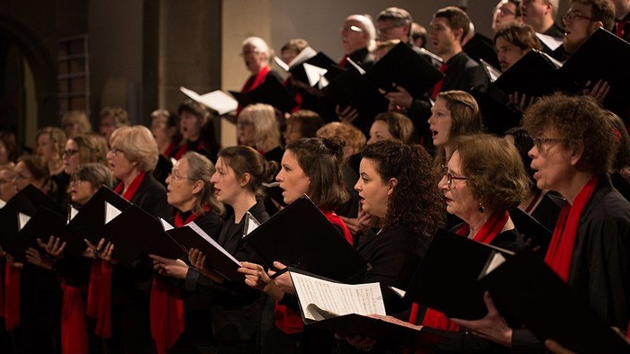 Großer Chor singt in der Kirche mit Notenblättern.