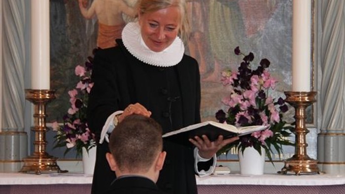 En præst udfører en religiøs ritual på en mand.