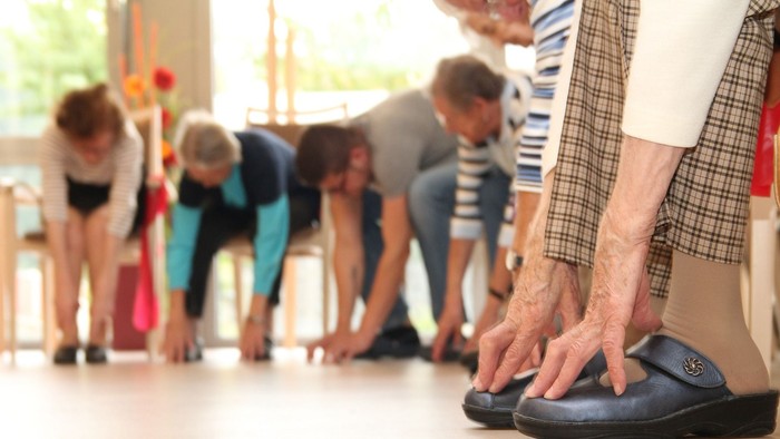 Gruppe von Menschen, die sich in einem Raum dehnt.