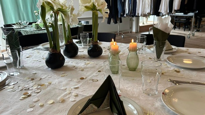 Bord dækket til spisning med blomster, stearinlys og servietter