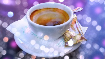Kaffeetasse mit Keks auf lila Hintergrund