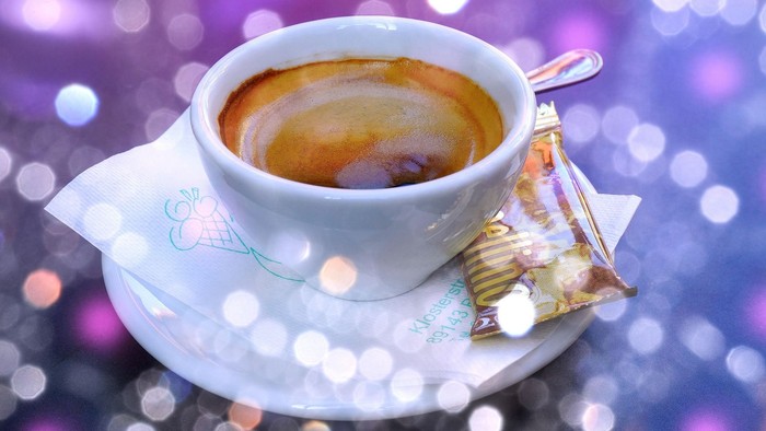 Kaffeetasse mit Keks auf lila Hintergrund