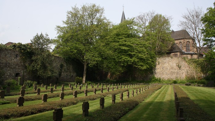 Gut gepflegter Friedhof mit Kirche im Hintergrund