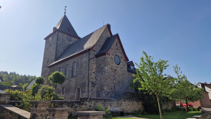 Altes steinernes Kirchgebäude mit spitzen Dach unter klarem Himmel