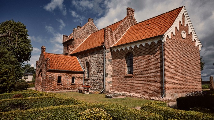 Det gamle stenhus med røde tag og mursten.