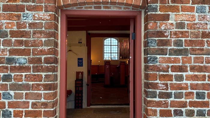 En rød murstensportal med lys over døren