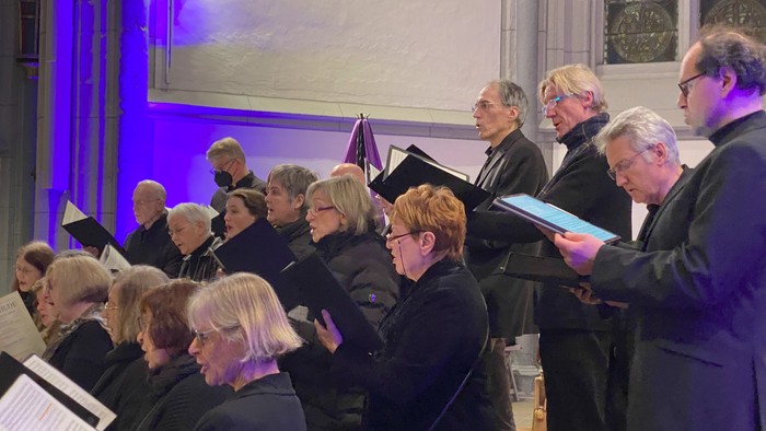 Ein Chor probt in einer Kirche unter der Leitung eines Dirigenten