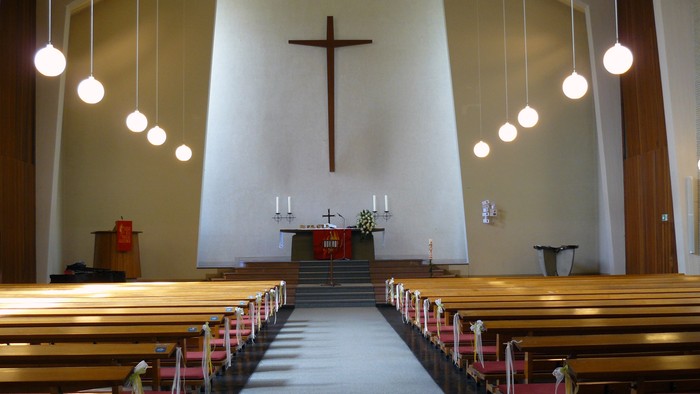 Leere Kirche mit Holzbänken und Kreuz