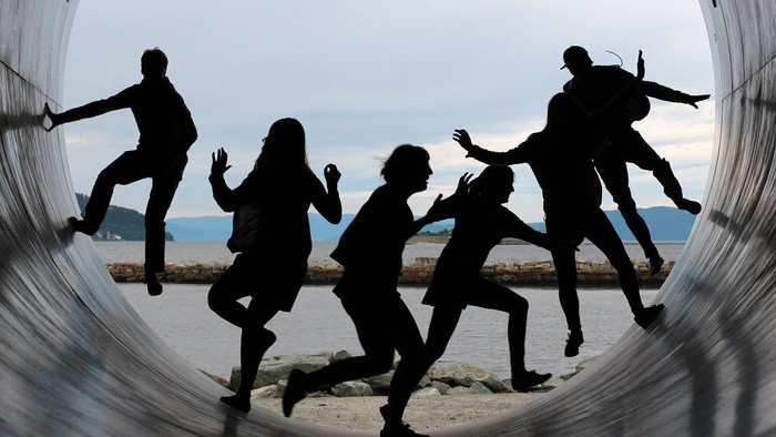 Silhouetten von Menschen am Strand, die spielen und rennen