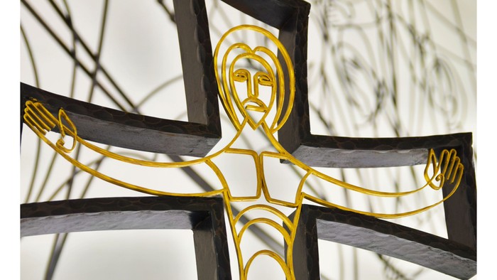Das Bild zeigt ein goldenes Kreuz mit einer Darstellung von Jesus Christus daran.