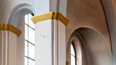 Bogenfenster mit goldenen Akzenten in hellem Raum