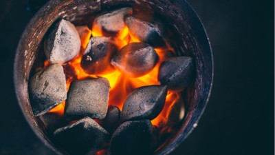 Glühende Holzkohle in einem Metallbehälter