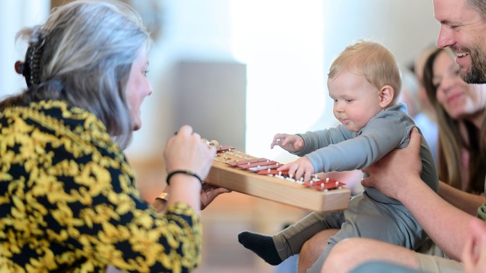 En kvinde med børn og mand ser på en kage.