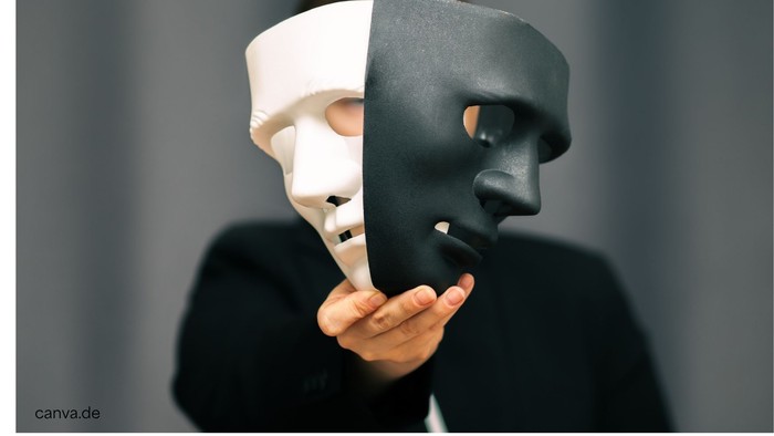 Eine Person hält eine geteilte Maske, eine Seite weiß und die andere schwarz, was die Dualität symbolisiert.