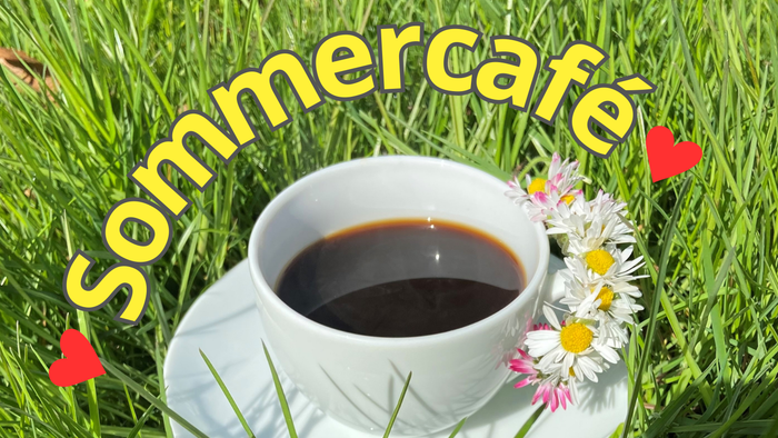 En kaffe i en tæppe på græs med sommercafé skrift og blomster
