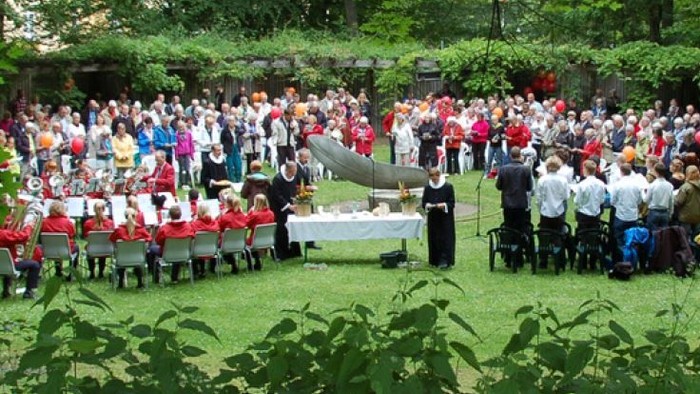 En stor gruppe af mennesker har samlet sig udendørs til en fest eller begivenhed.