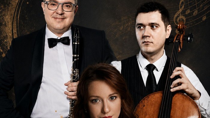 Klassische Musiker, die mit einem Cello und einem Flügel in einem eleganten, vintage-inspirierten Ambiente posieren.